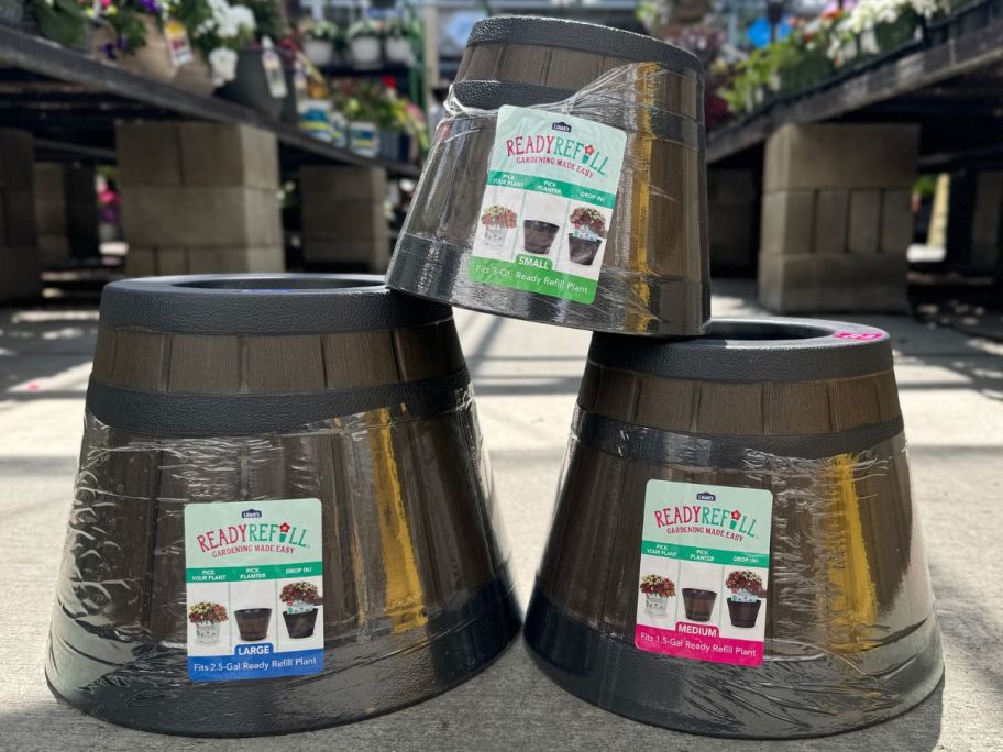 3 whiskey barrel style resin planters stacked in the garden department at Lowe's