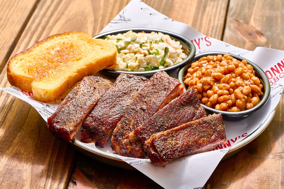 ribs, garlic bread, coleslaw and baked beans on a platter