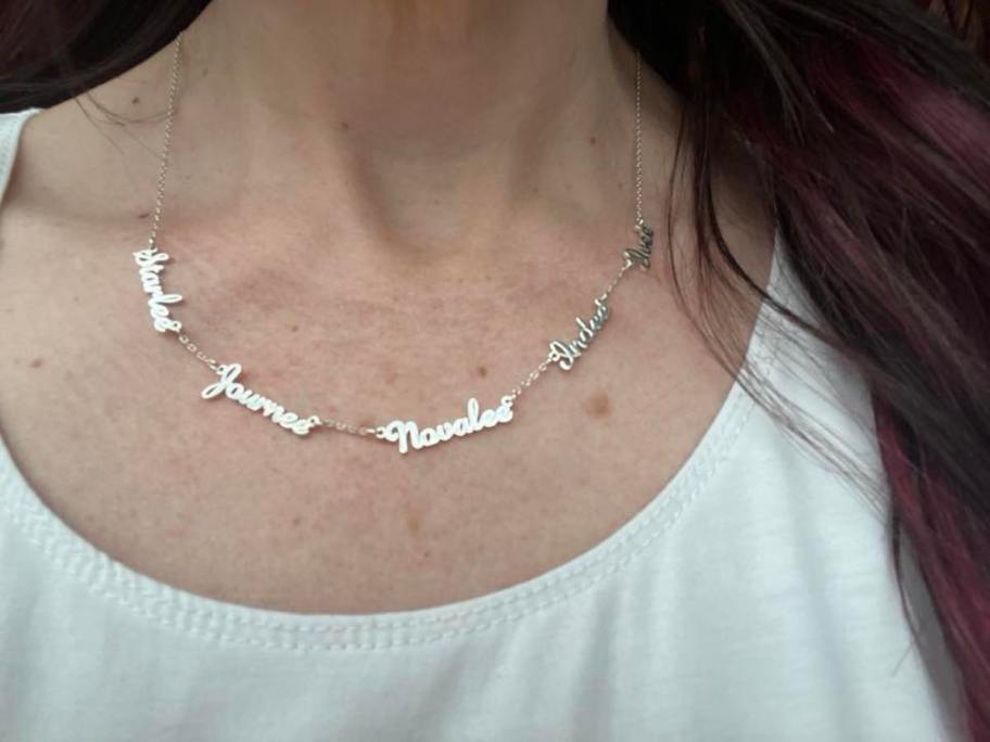 close up of silver name necklace on womans neck