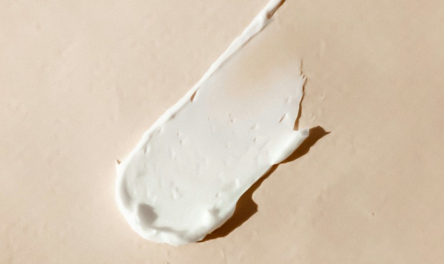 white lotion smeared on beige background