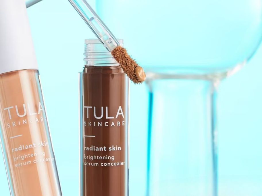 TULA Radiant Skin Brightening Serum Concealers in front of blue background
