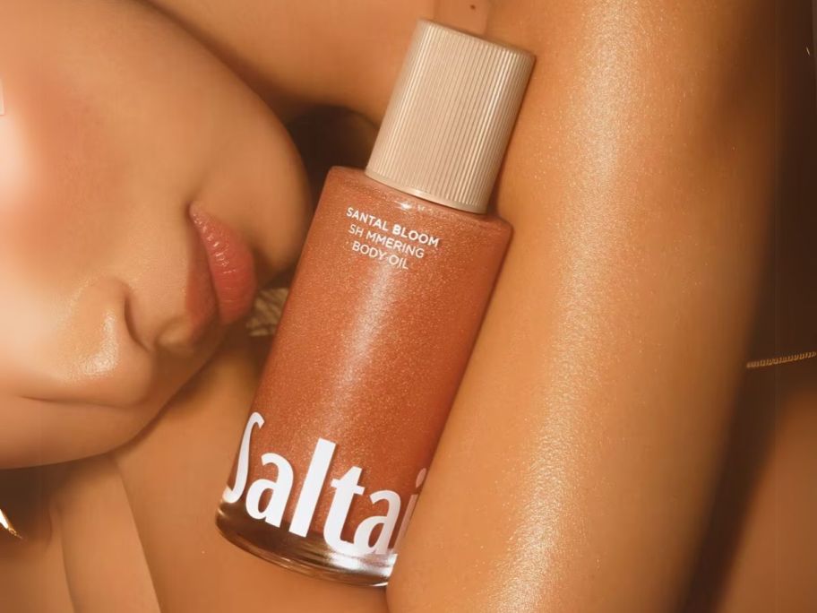 Saltair Shimmering Body Oil bottle on woman's arm