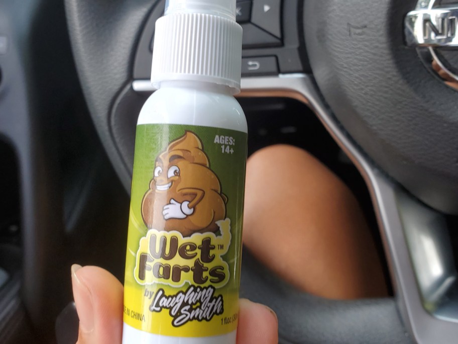holding a bottle of fart spray