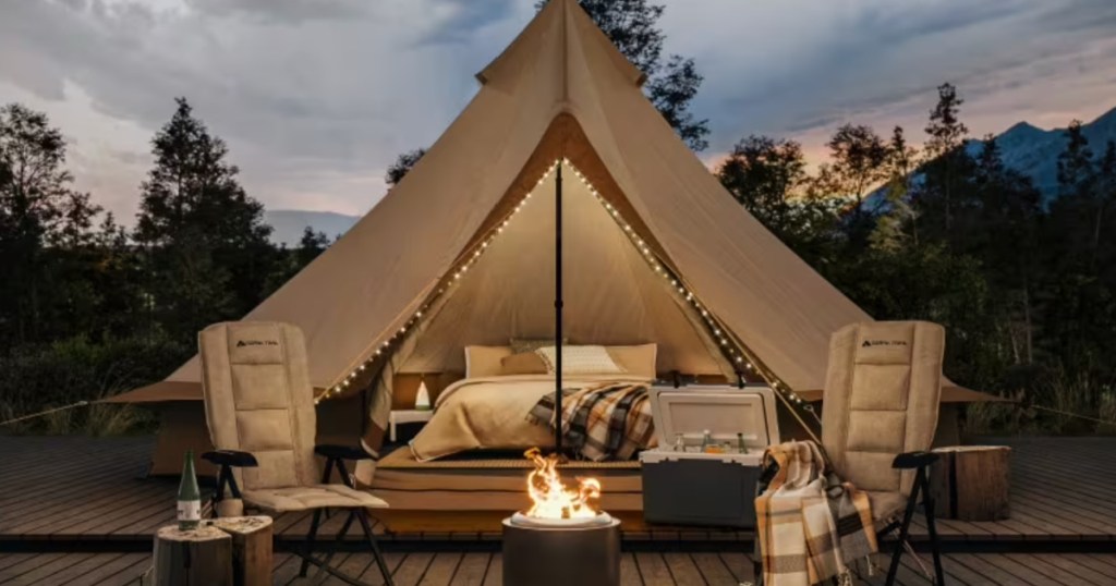 Large glamping yurt tent set up with sleeping bags on a wooden deck platform