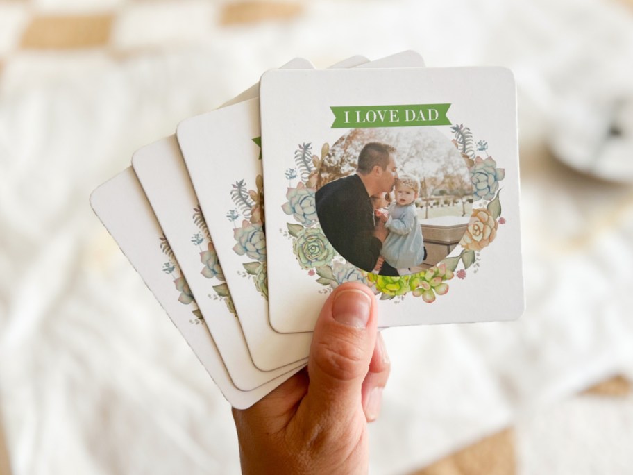 Hand holding fathers day coasters