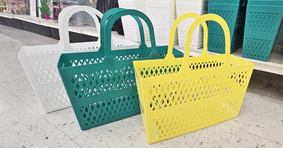 yellow, teal, and white jelly totes on floor in store