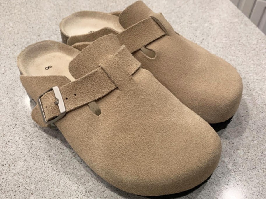 pair of suede clogs on counter