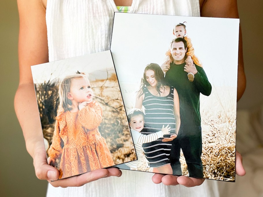 woman holding up two wood photo panels