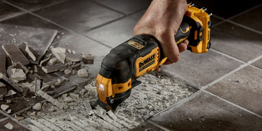 hand using dewalt ocillating tool on tile 