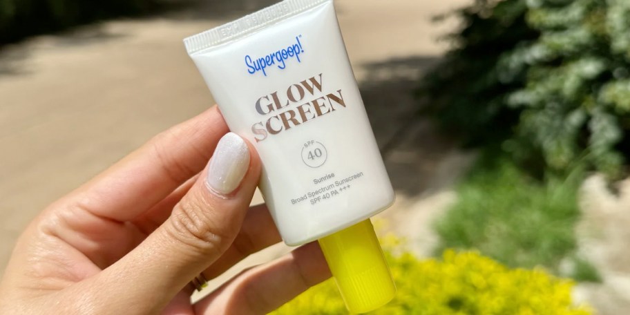 hand holding supergoop spf 