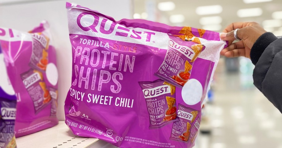 hand holding a purple bag of Quest Spicy Sweet Chili Tortilla Chips in store