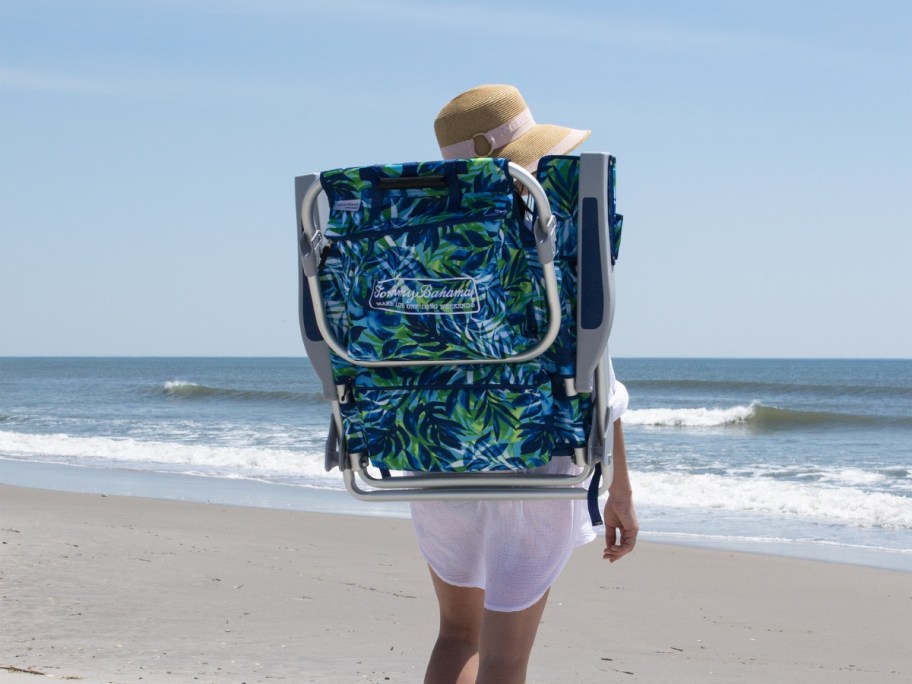 woman wearing tommy bahama beach chair while walking on beach