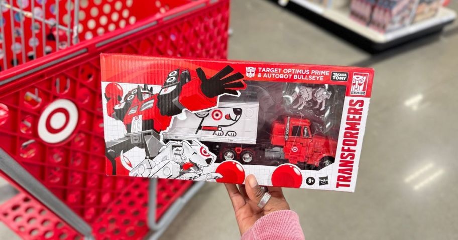 Transformers Target Optimus Prime and Autobot Bullseye Action Figure Set being held bt hand in store in front of target cart
