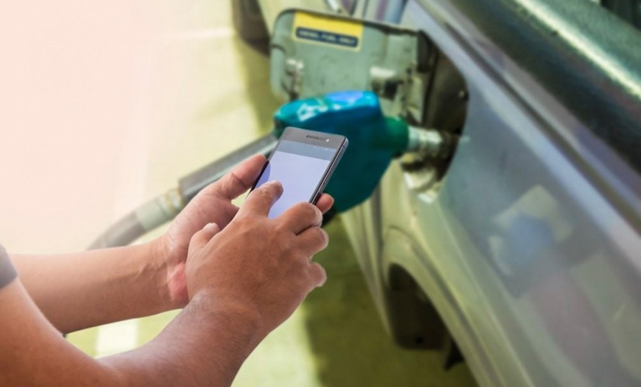 person using phone at gas pump