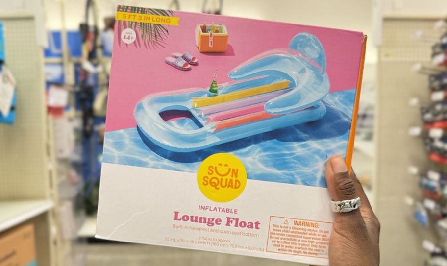 a womans hand holding a boxed lounge chair pool float