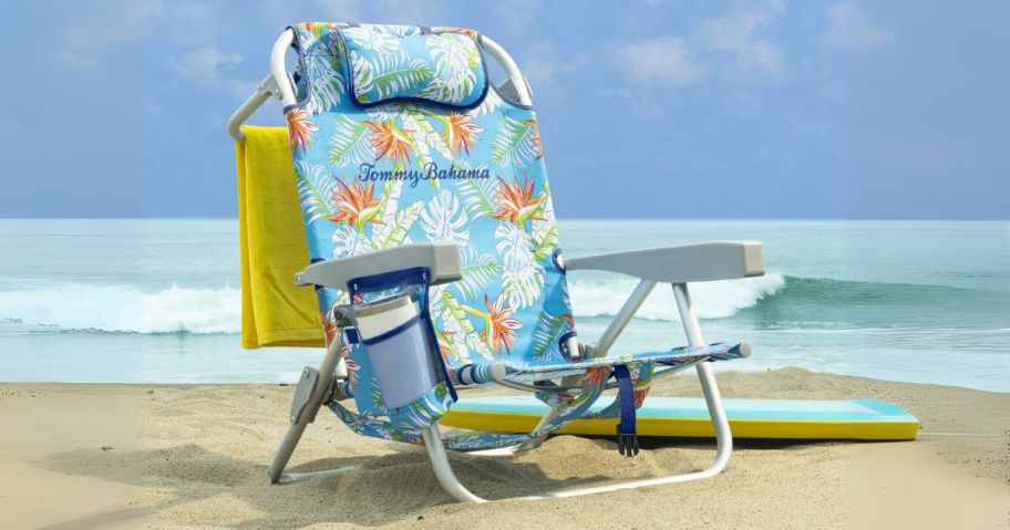 tommy bahama beach chair on the beach with towel hanging hanging off the back of it