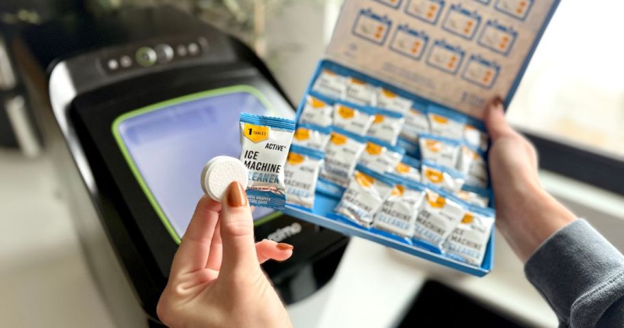 A person holding an Active Ice Machine cleaner tablet