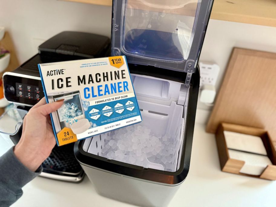 A person holding an Active Ice Machine cleaner tablet box