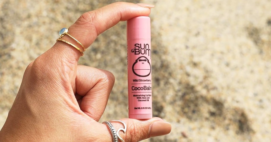 hand holding a pink tube of Sun Bum Cocobalm 