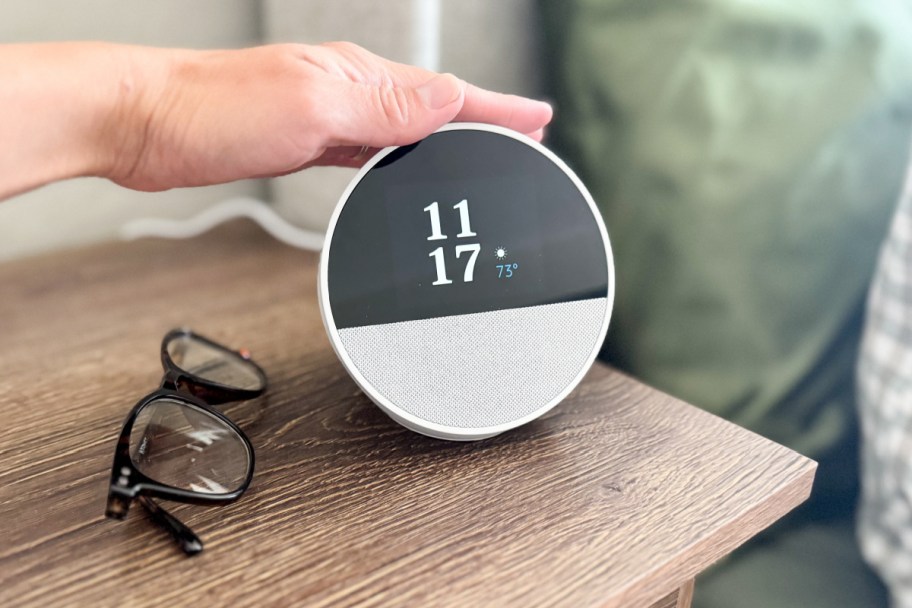 hand tapping round alarm clock with half screen