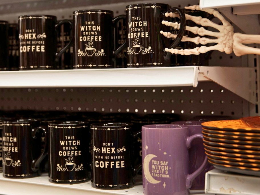 Halloween themed coffee mugs on shelves in a store