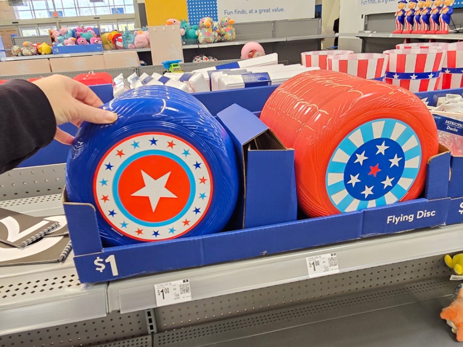 hand reaching for patriotic flying discs on shelf