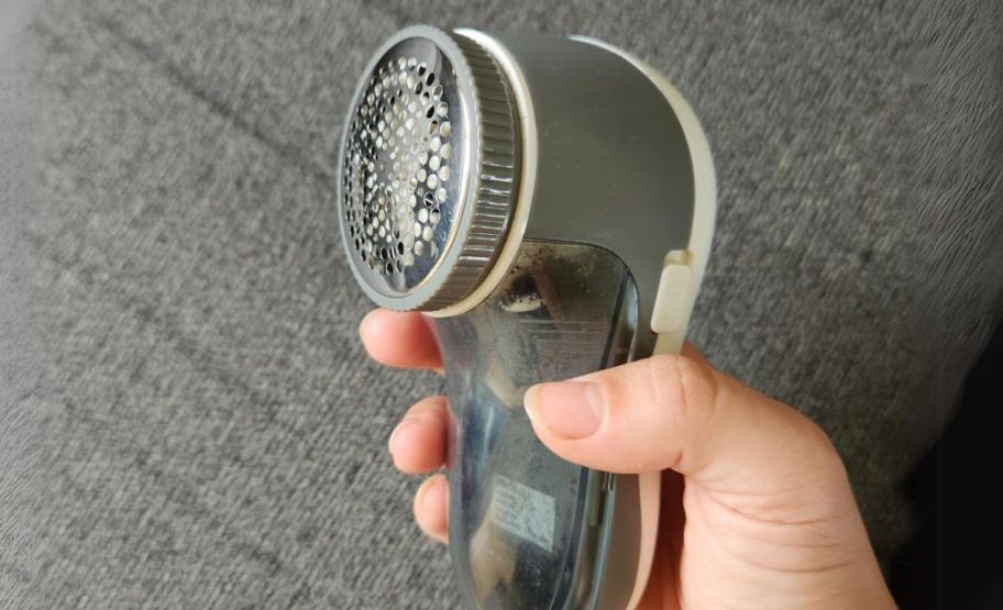person holding a fabric shaver
