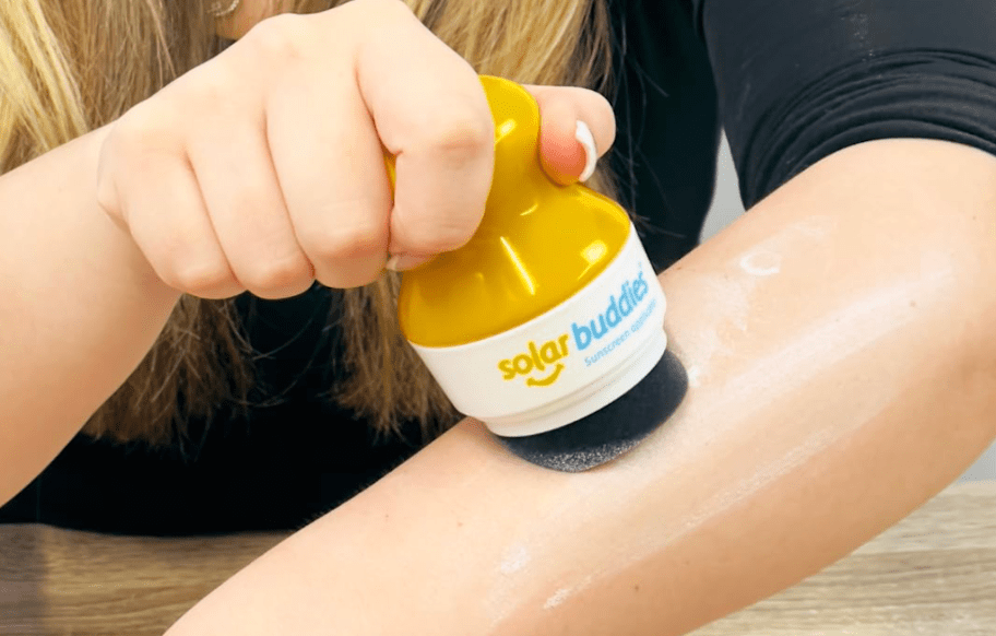 person applying sunscreen using a Solar Buddies 