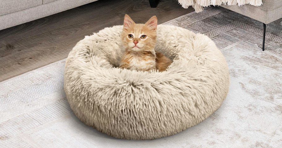 cat inside a taupe faux fur donut pet bed
