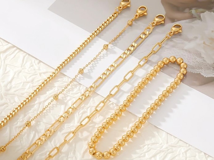 5 gold bracelets laying on table