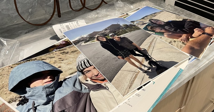 3 photo poster prints laying on a counter, images of people outdoors