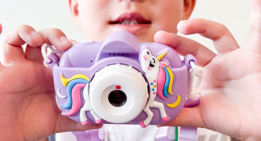 Kid holding unicorn digital camera