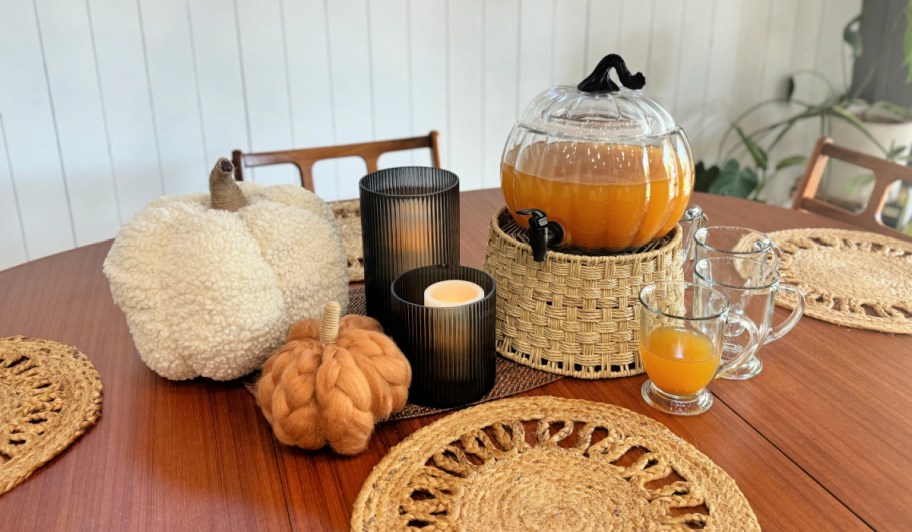 walmart fall decor displayed on a table near a glass pumpkin beverage dispenser filled with apple cider