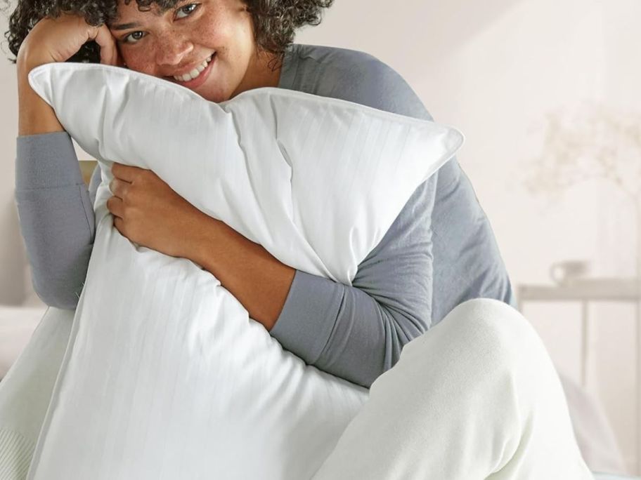 A woman hugging a pillow