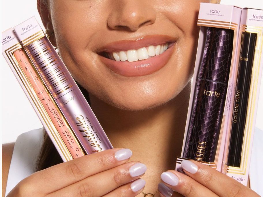 Woman holding 4 Tarte Eye Makeup Products