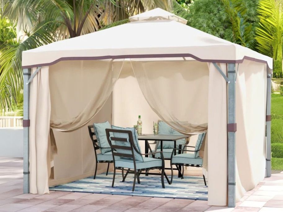 white gazebo with patio set underneath on deck