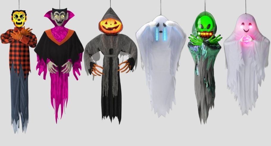 a werewolf, vampire, pumpkin head, crying ghost, green alien and heart hands ghost figures as hanging light and sound scene props