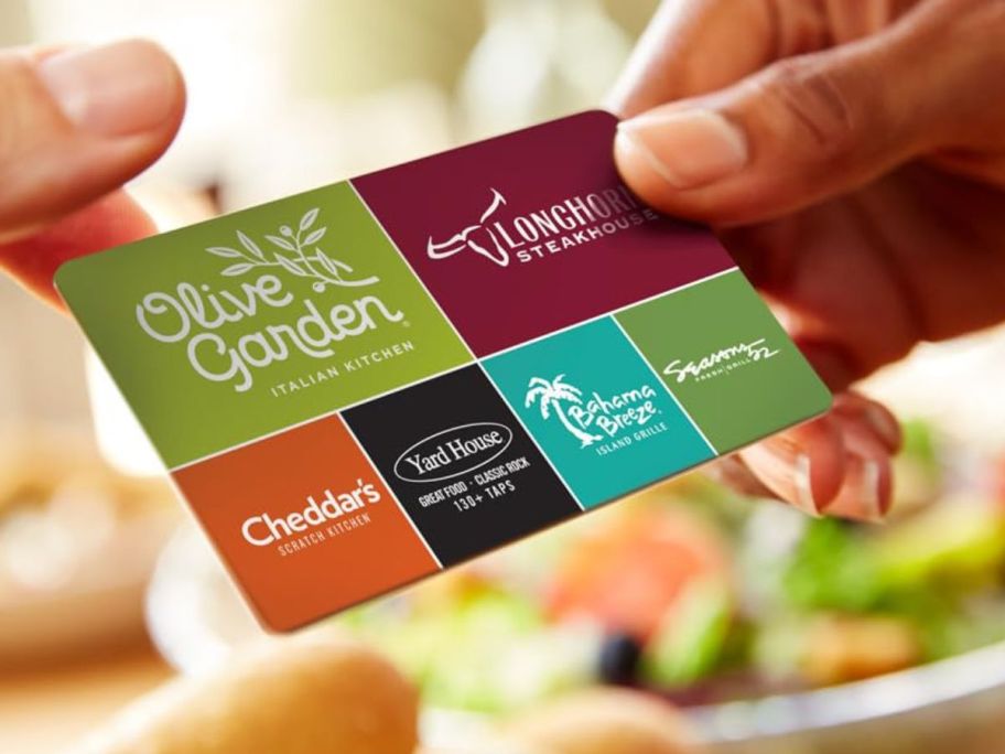 A person passing another a gift card for chain eateries
