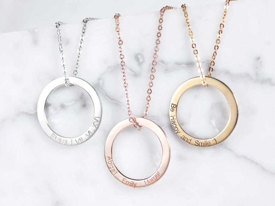 3 necklaces with circle charms on them