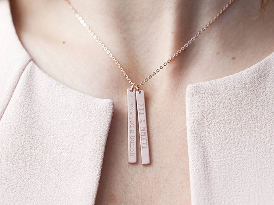 A woman wearing a necklace with 2 bars on it 