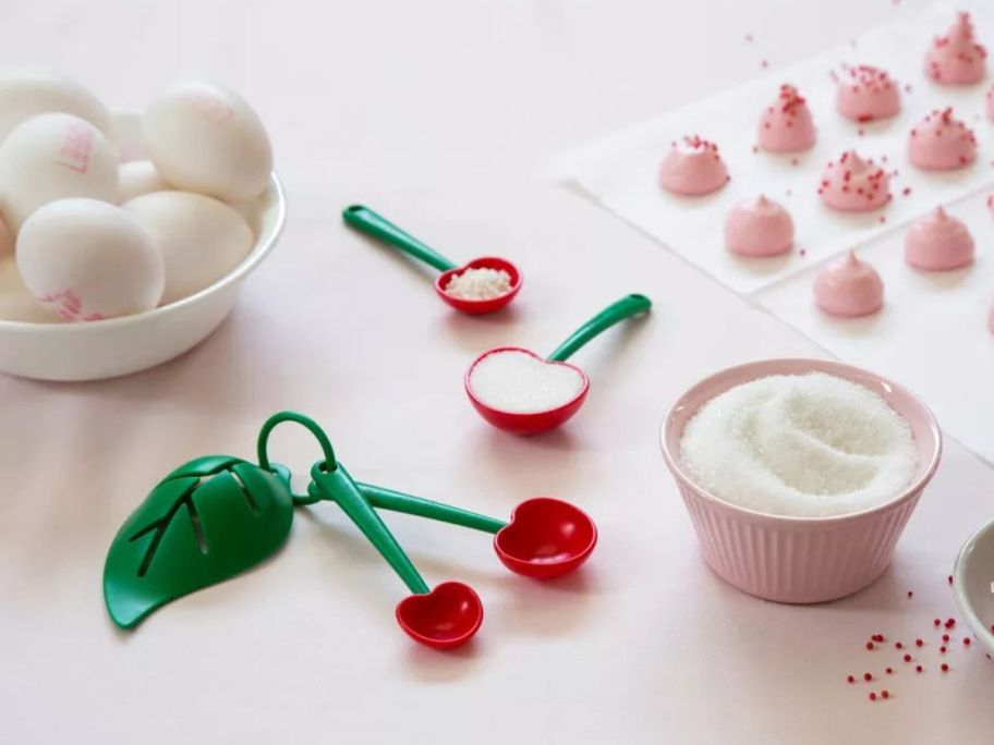 OTOTO Mon Cherry Measuring Spoons & Egg Separator on kitchen counter amongst baking ingredients