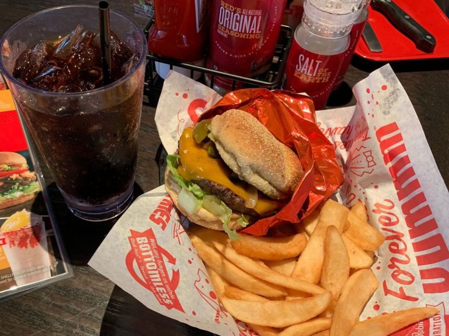 A glass of soda and a basket with a Burger and fries at Red Robin