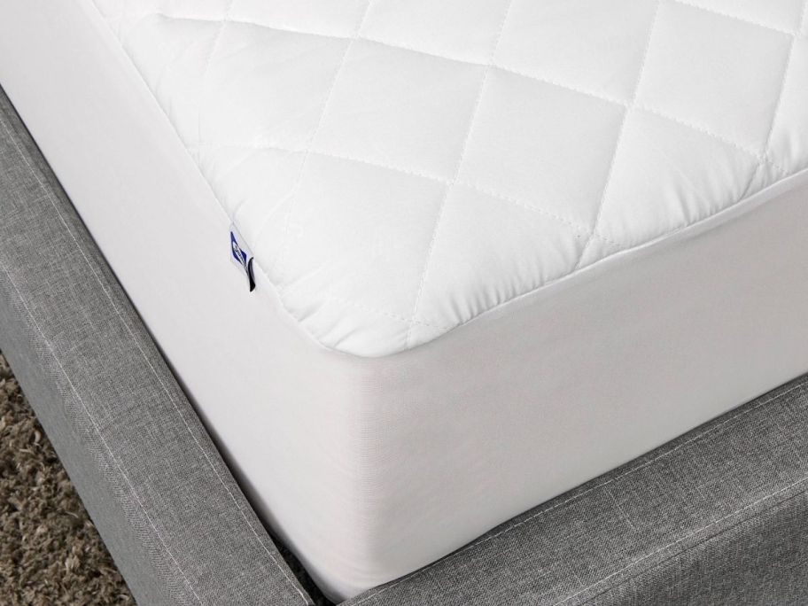 the corner of a mattress covered with a mattress topper