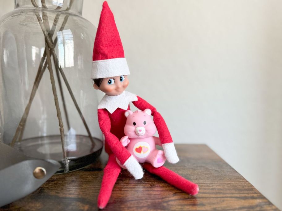 An Elf on the Shelf with a World's Smallest Care Bear in its lap