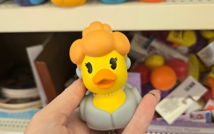 a womans hand holding a rubber duckie