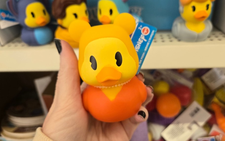 a womans hand holding a rubber duckie