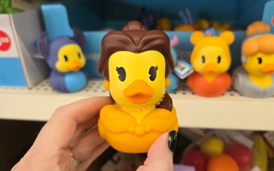 a womans hand holding a rubber duckie
