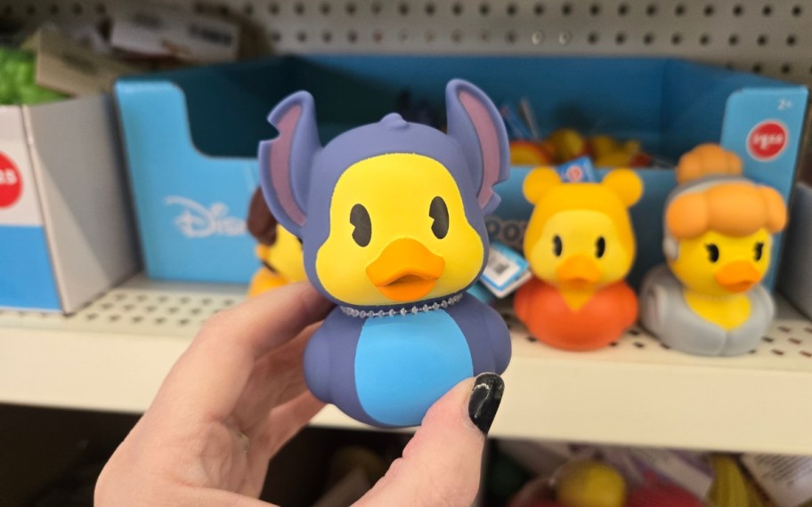 a womans hand holding a rubber duckie
