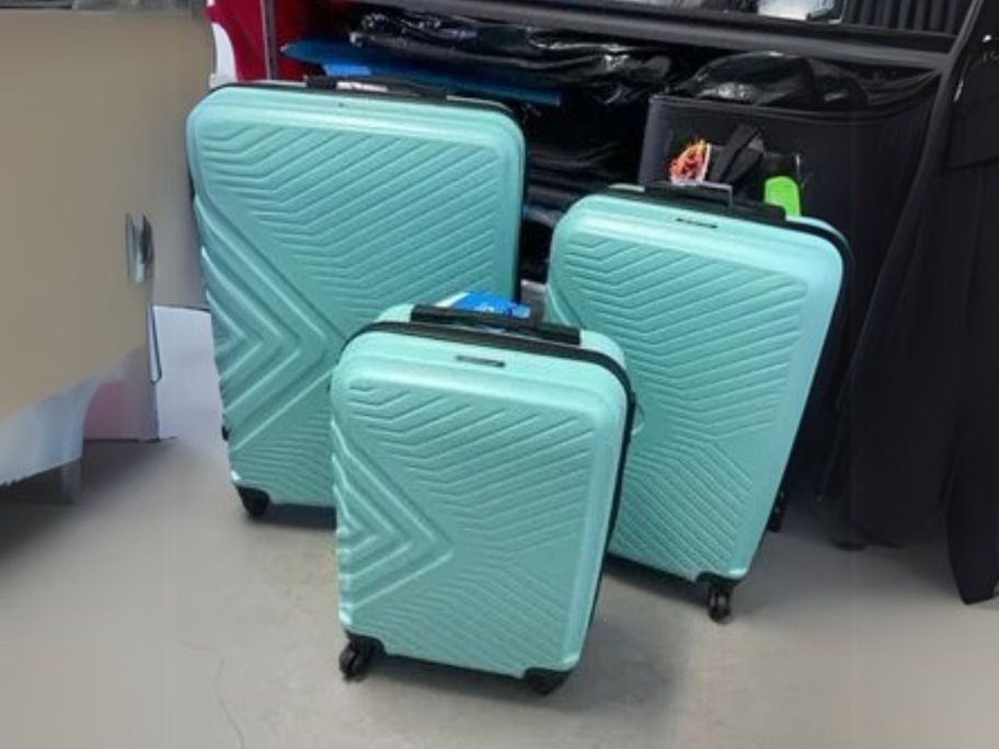 three light green travelhouse luggage pieces in airport