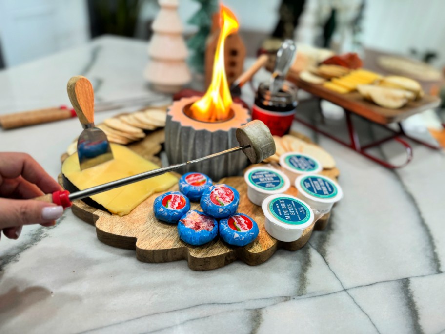 roasting a piece of brie on indoor fire pit 
